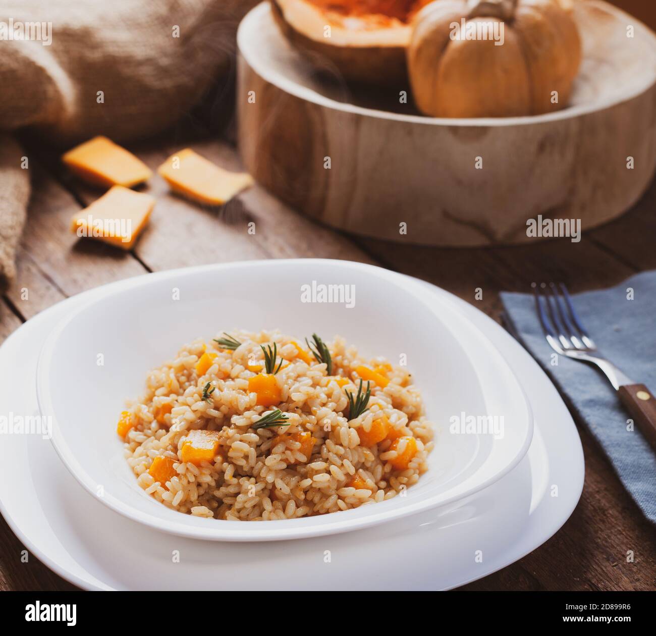 Kürbisrisotto, Rezept mit Reis und Kürbis auf rustikalem Tisch mit Zutaten. Herbst und Halloween Rezept. Stockfoto