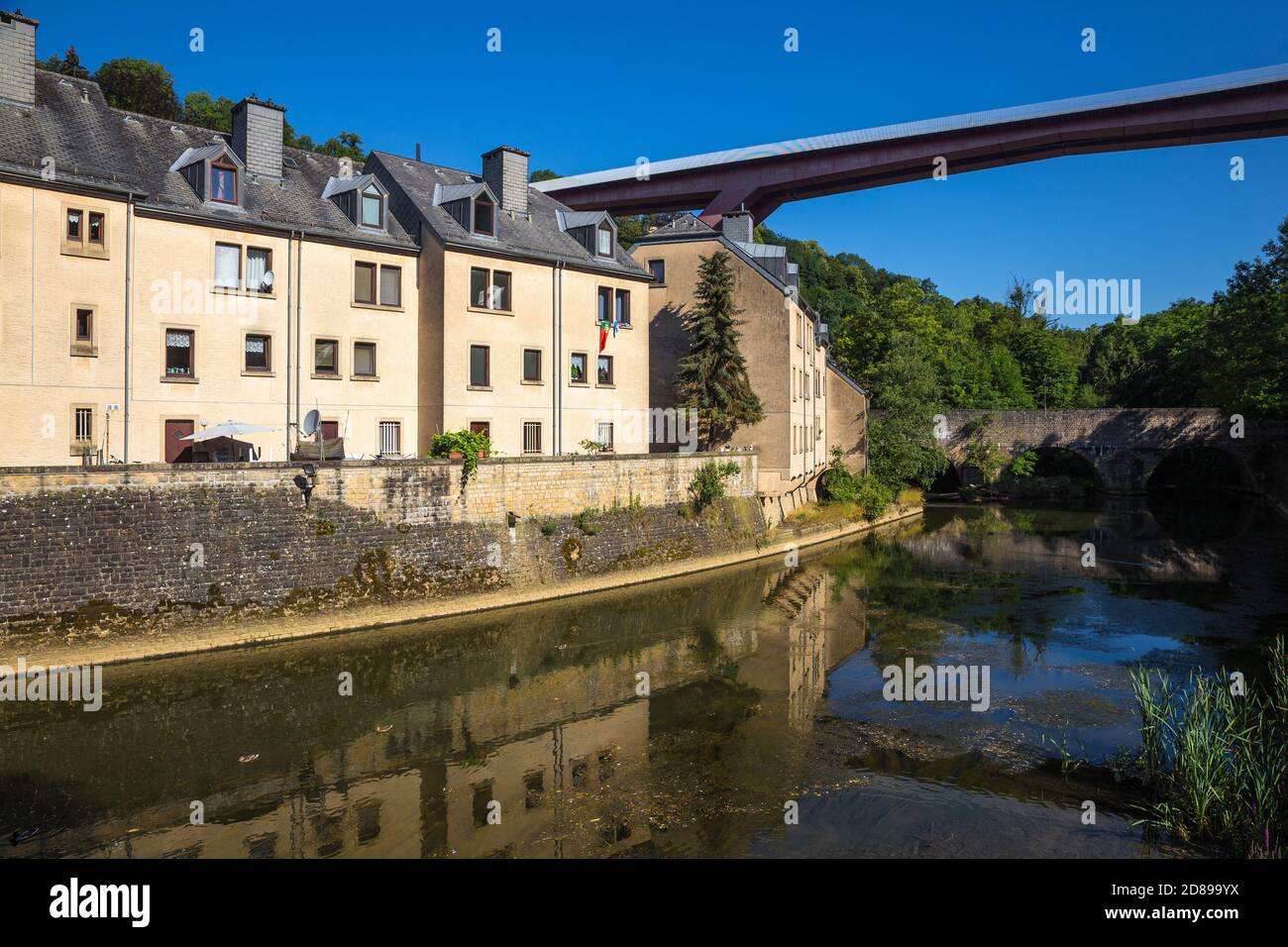 Luxemburg, Stadt Luxemburg, Pfaffenthal, Häuser neben einem Nebenfluss des Flusses Sure und der Großherzogin Charlotte Brücke bekannt als die Rote Brücke Stockfoto