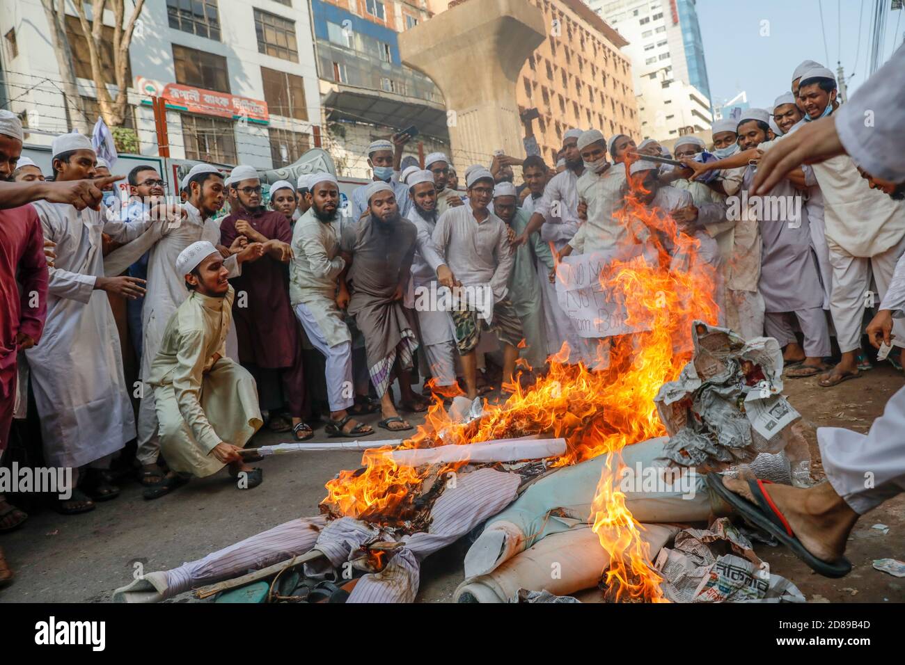 Aktivisten von Islami Oikyajot Bangladesh, einer islamistischen politischen Partei, brennen französische Nationalflagge und Bildnis von Emmanuel Macron, während sie sich in einer de versammeln Stockfoto