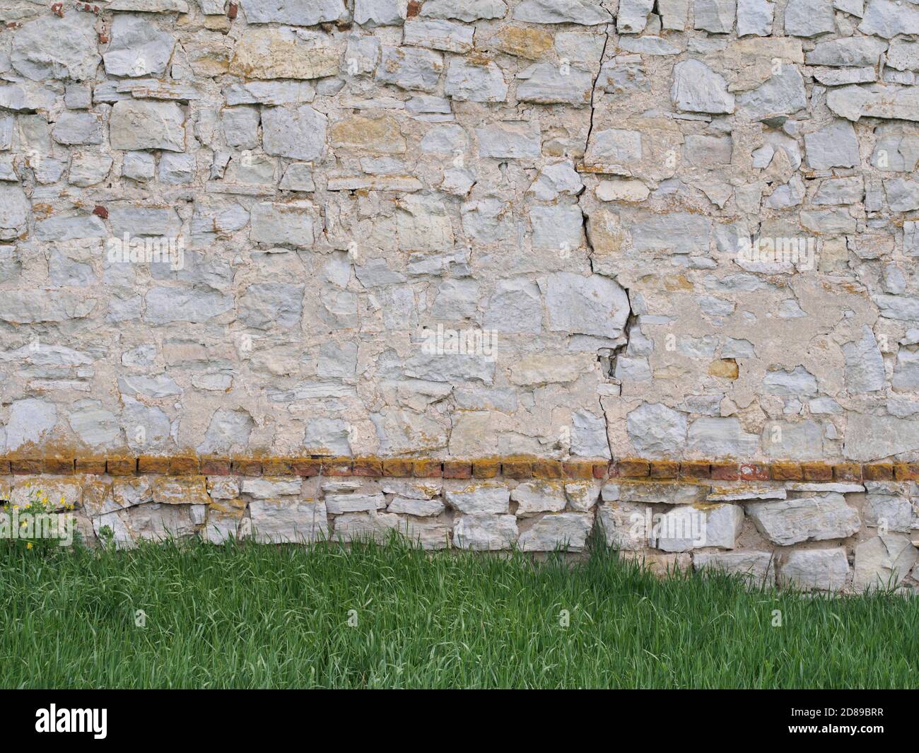 Steinmauer auf dem Rasen Wiese Hintergrund Stockfoto