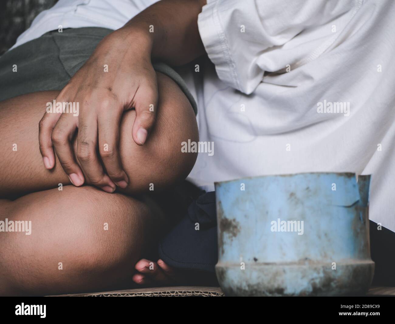 Unglückliche streunende Kind legte sich auf schmutzigen Boden auf der Brücke und braucht jemand Hilfe für Essen und Geld. Armut, Hunger Menschen und Menschenrechte Konzept. Stockfoto