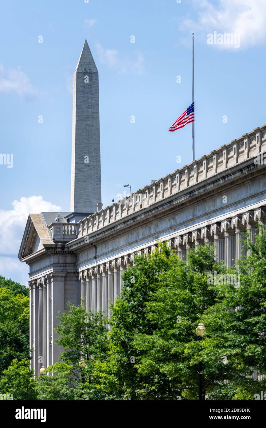 Das 555' Washington Monument erhebt sich über der griechisch inspirierten ionischen Kolonnade des US Treasury Building, das sich 350' entlang der 15th Street, NW, erstreckt. Stockfoto