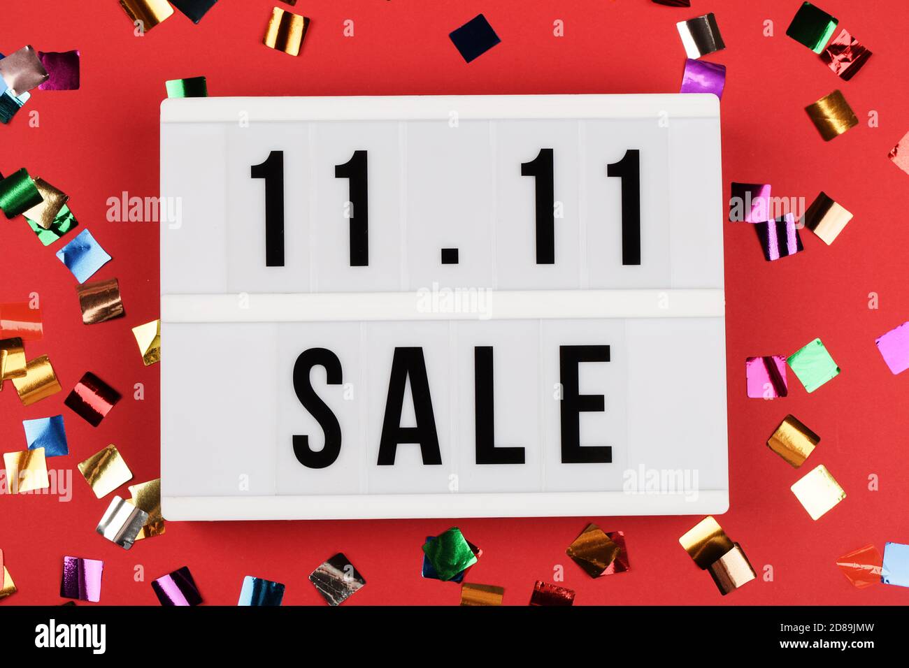 11.11 Verkaufstext auf weißem Leuchtkasten auf rotem Hintergrund. Online-Shopping, Single-Day-Sale-Konzept. Kopiespeicherplatz in der Draufsicht Stockfoto