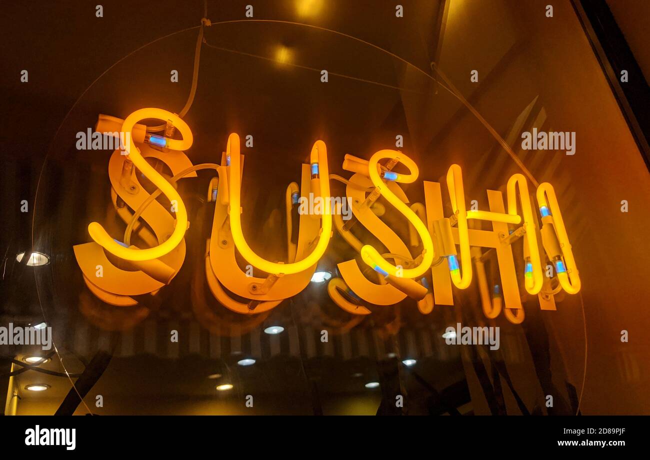 Sushi-gelbe Neonbeleuchtung auf dem Restaurantfenster Stockfoto