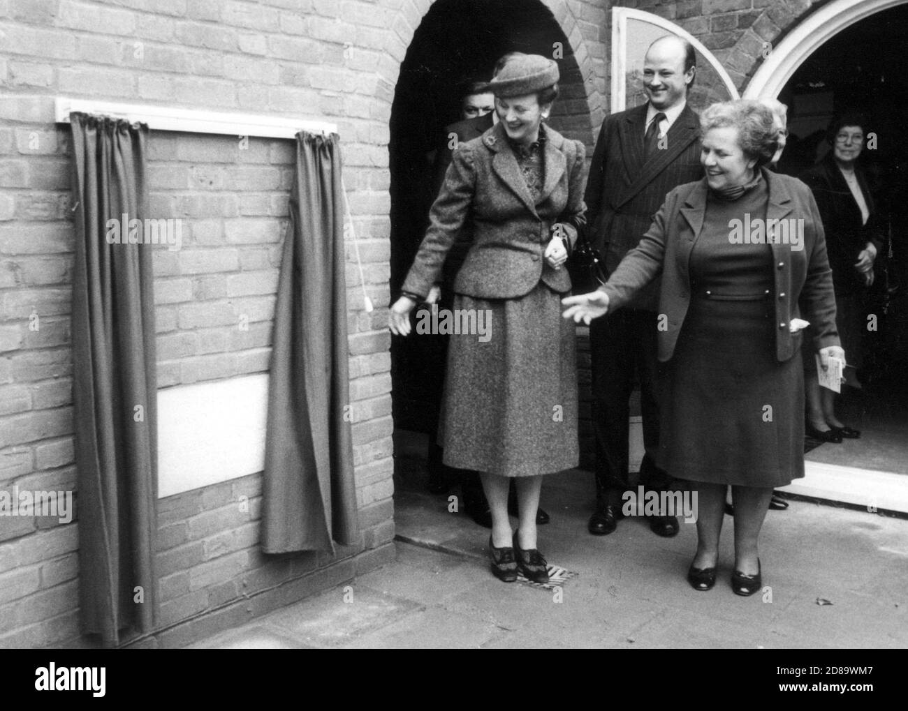 IHRE MAJESTÄT KÖNIGIN VON DÄNEMARK, KÖNIGIN MARGARETHE II. ENTHÜLLT DEN GRUNDSTEIN DES NEUEN MUSIKRAUMES IN DER NORTH FORELAND LODGE SHERFIELD IN LODDEN, ENGLAND, BEOBACHTET VON DIREKTORIN MISS ROSMARIN IRVINE. 1983 Stockfoto