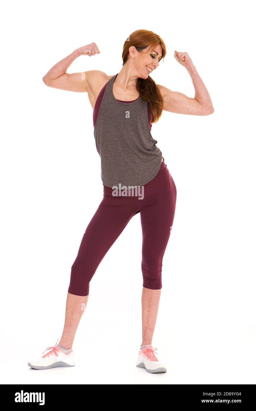 In voller Länge Porträt von gesunden reifen Frau in Sportbekleidung Flexing Ihr Bizeps auf weißem Hintergrund Stockfoto
