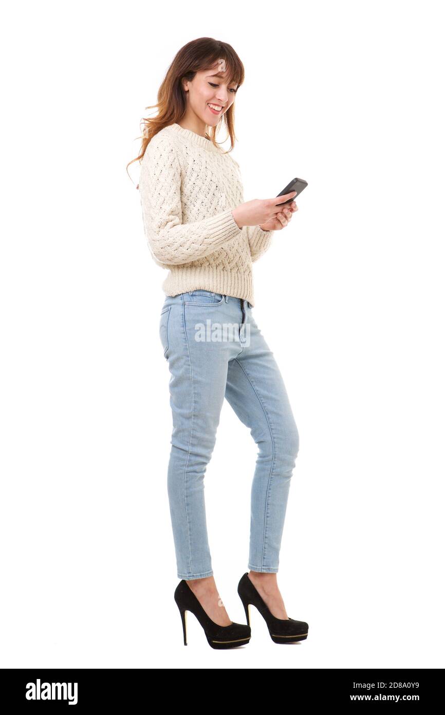 In voller Länge Porträt von lächelnden jungen Frau hält Handy gegen Isolierter weißer Hintergrund Stockfoto