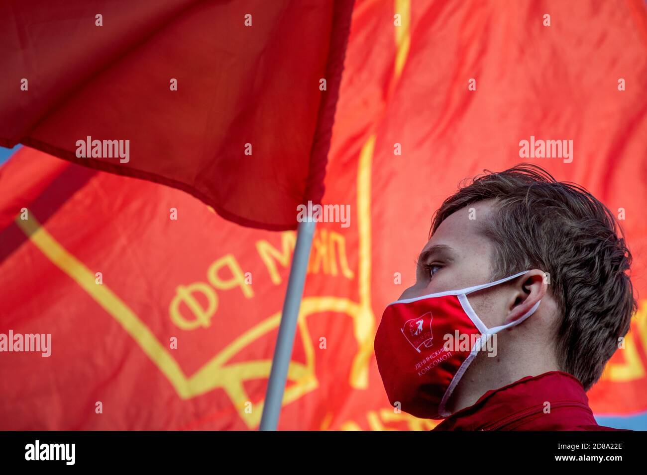 Moskau, Russland. 28. Oktober 2020 EIN Anhänger der kommunistischen Partei, trägt eine rote Gesichtsmaske mit sowjetischem Komsomolabzeichen, nimmt an der Kundgebung der Kommunistischen Partei auf dem Roten Platz Teil, um den 102. Jahrestag des Komsomol zu begehen, Oder die All-Union Leninist Young Communist League, die kommunistische Jugendorganisation der Sowjetzeit, in Moskau während der neuartigen Coronavirus COVID-19 Krankheit in Russland Stockfoto