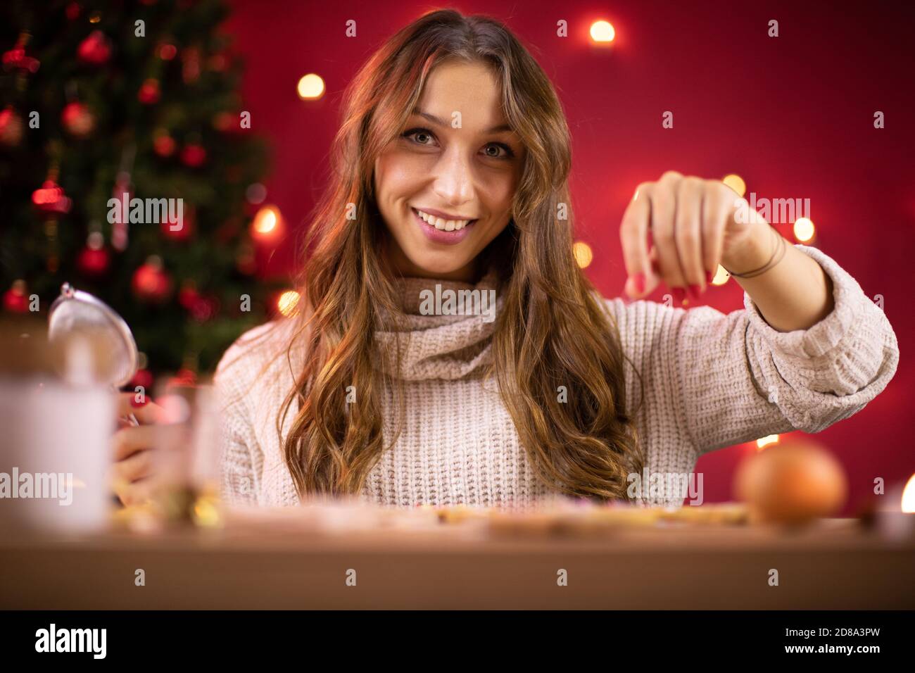 Schöne Frau macht Weihnachtsplätzchen Dekoration Lebkuchen mit Zucker Sprinles Stockfoto