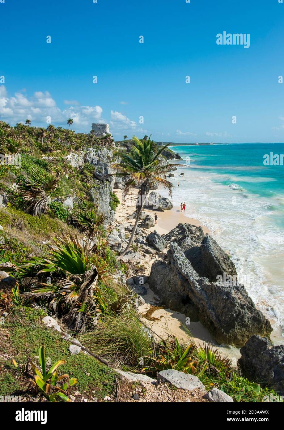 Tulum, Mexiko - 12. März 2020: Touristen an einem karibischen Strand in Tulum, Yucatan, Mexiko. Auf der Klippe in der Ferne ist einer der Tempel der Stockfoto