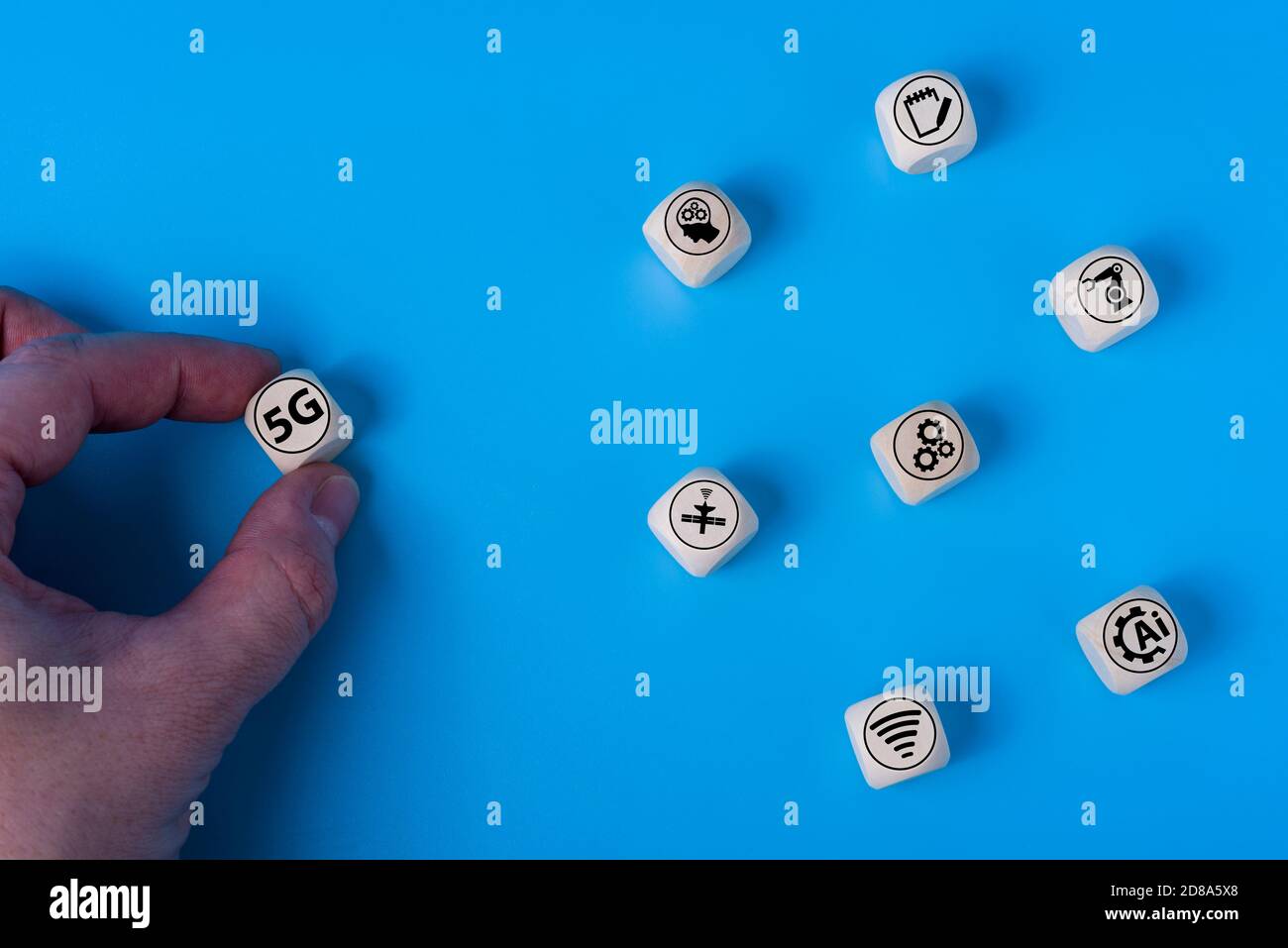 Konzept von 5G mit Symbolen auf Holzwürfeln. Blauer Hintergrund. Das Konzept der Technologien der Zukunft. Stockfoto