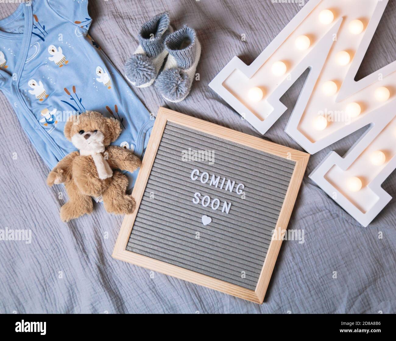 In Kürze verfügbar. Baby Ansagetafel auf grauem Hintergrund. Demnächst erhältlich. Stockfoto