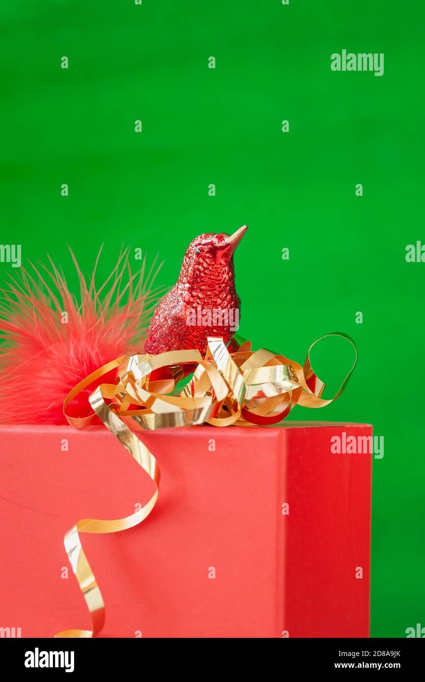 Funkelnde Weihnachtsdekorationen mit funkelndem Glas Vogel auf roter Geschenkbox, New Yea und Weihnachtsdekor. Heller Hintergrund, Kopierbereich Stockfoto