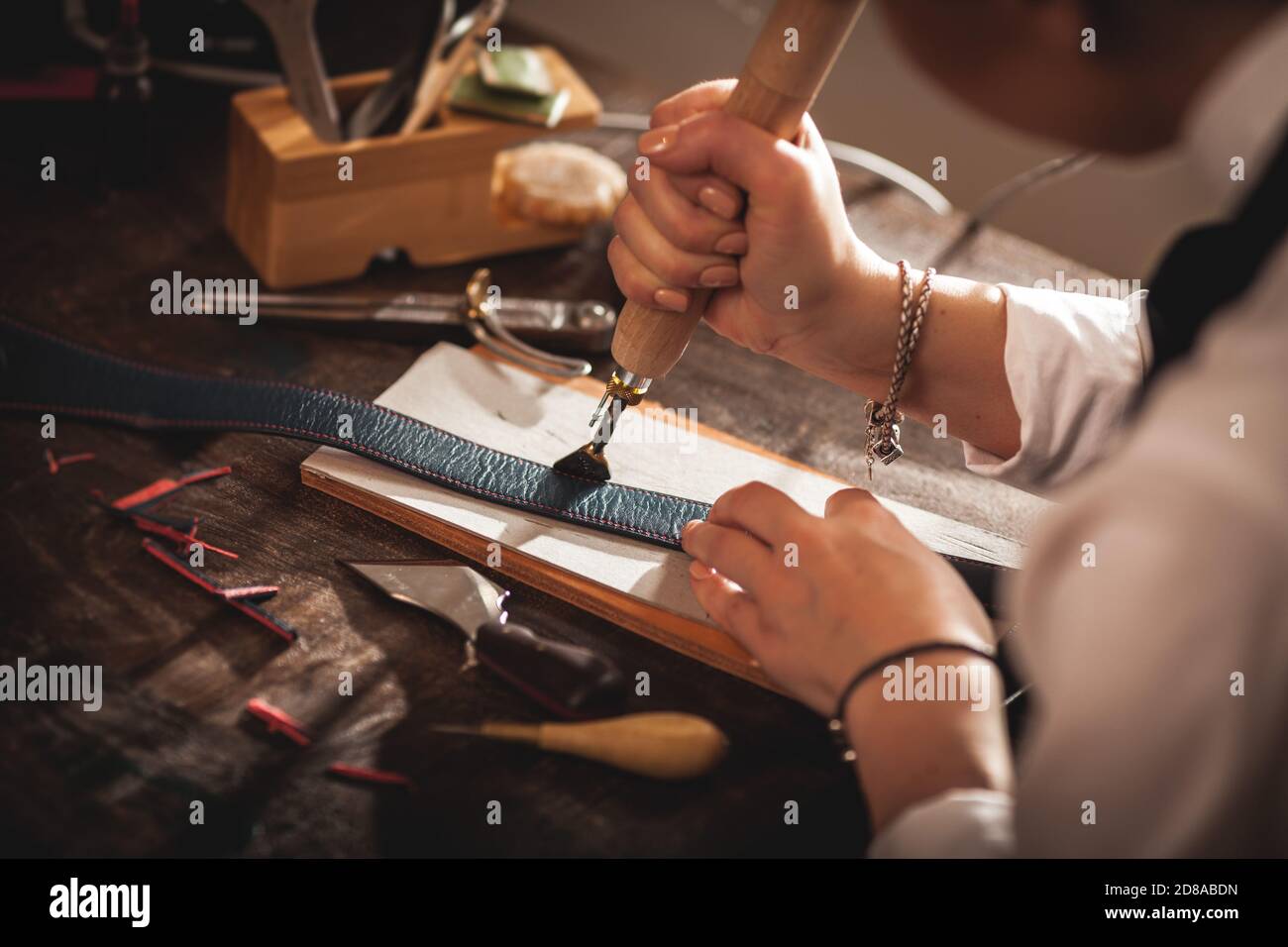 Lederhandtasche Handwerker bei der Arbeit in einer Vintage-Werkstatt. Konzept für kleine Unternehmen Stockfoto