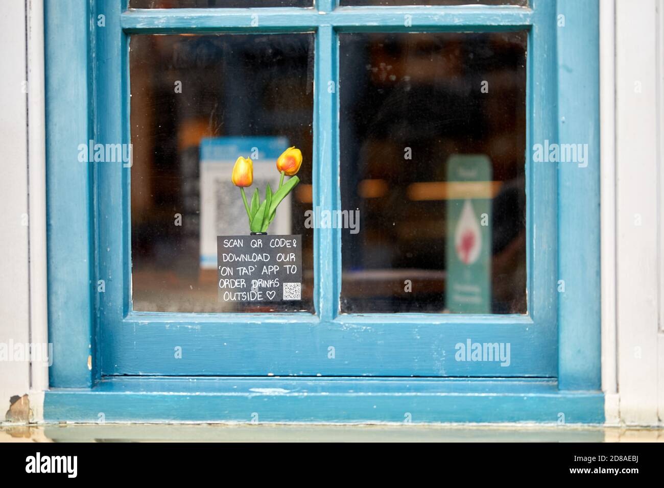 London, Großbritannien. - 28. Oktober 2020: Ein Schild im Fenster eines Londoner Pubs ermutigt Kunden, über ihr Telefon draußen zu bestellen, anstatt das Gebäude zu betreten. Stockfoto