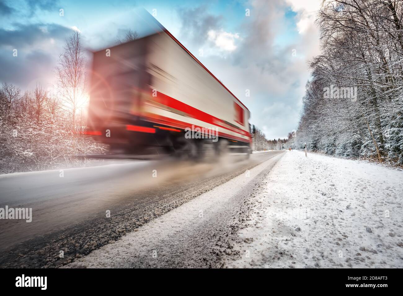 LKW auf Asphaltstraße im Winter am sonnigen Morgen Stockfoto