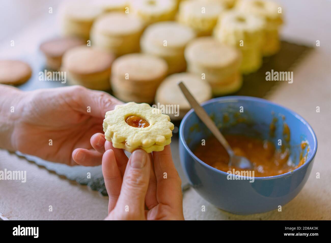 Oma macht traditionelle deutsche spitzbuben weihnachtskekse linzer Keks Cookies gefüllt Mit Marmelade Stockfoto