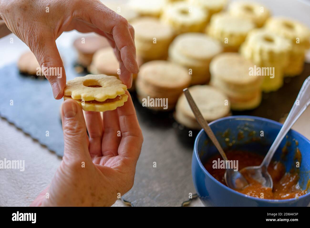 Oma macht traditionelle deutsche spitzbuben weihnachtskekse linzer Keks Cookies gefüllt Mit Marmelade Stockfoto