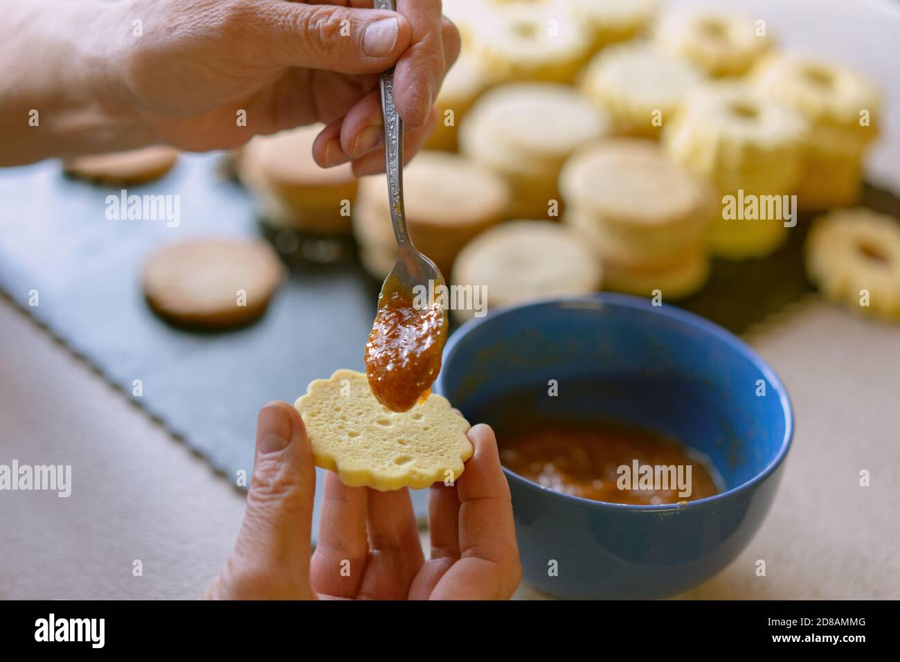 Oma macht traditionelle deutsche spitzbuben weihnachtskekse linzer Keks Cookies gefüllt Mit Marmelade Stockfoto