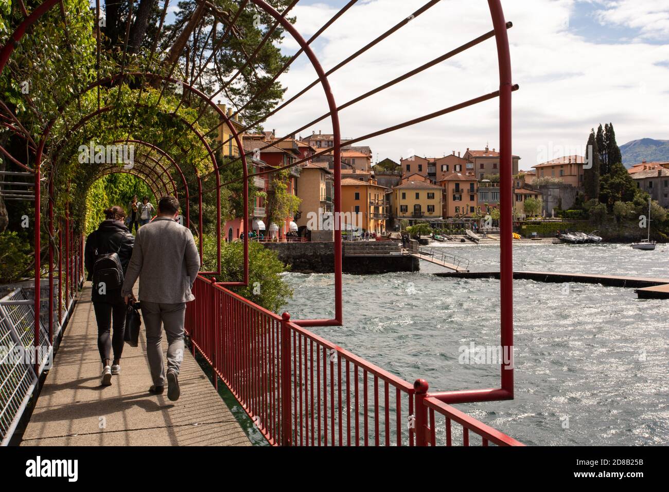 Touristen gehen auf der Promenade entlang des Comer Sees in der Nähe von Varenna Stockfoto