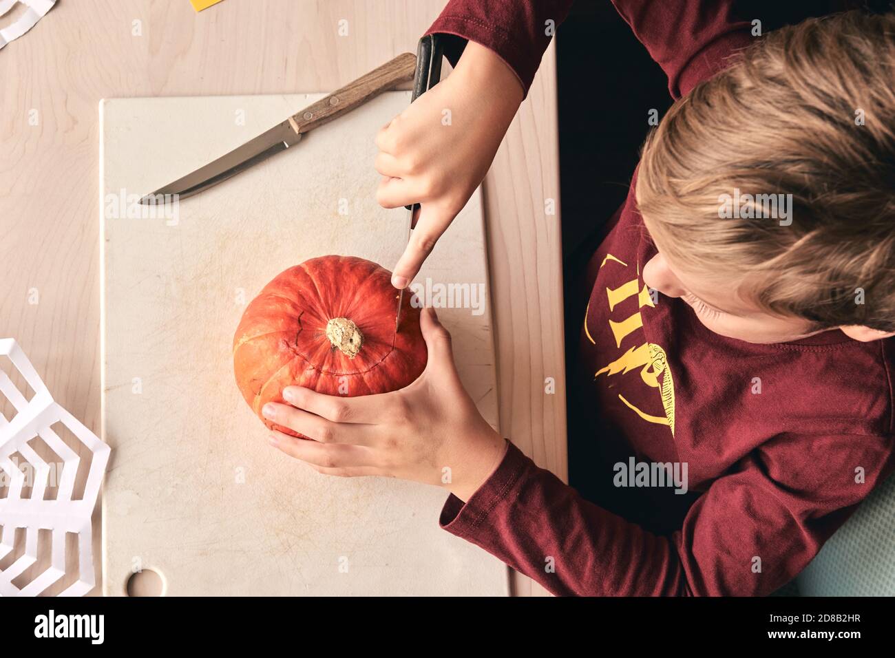 Halloween, Dekoration und Urlaub Ideen- Nahaufnahme des Kindes mit Messer Schnitzerei Kürbis oder Jack-o-Laterne. 6 Jahre junge hat Heimfamilie Spaß Aktivität. Mama Stockfoto