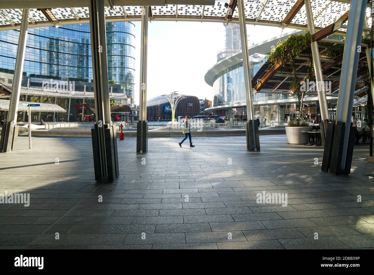 Mailand - 10/28/2020: Eine Frau zu Fuß in einem leeren Geschäftsviertel - Place Gae Aulenti, Milano Porta Nuova Bezirk Stockfoto