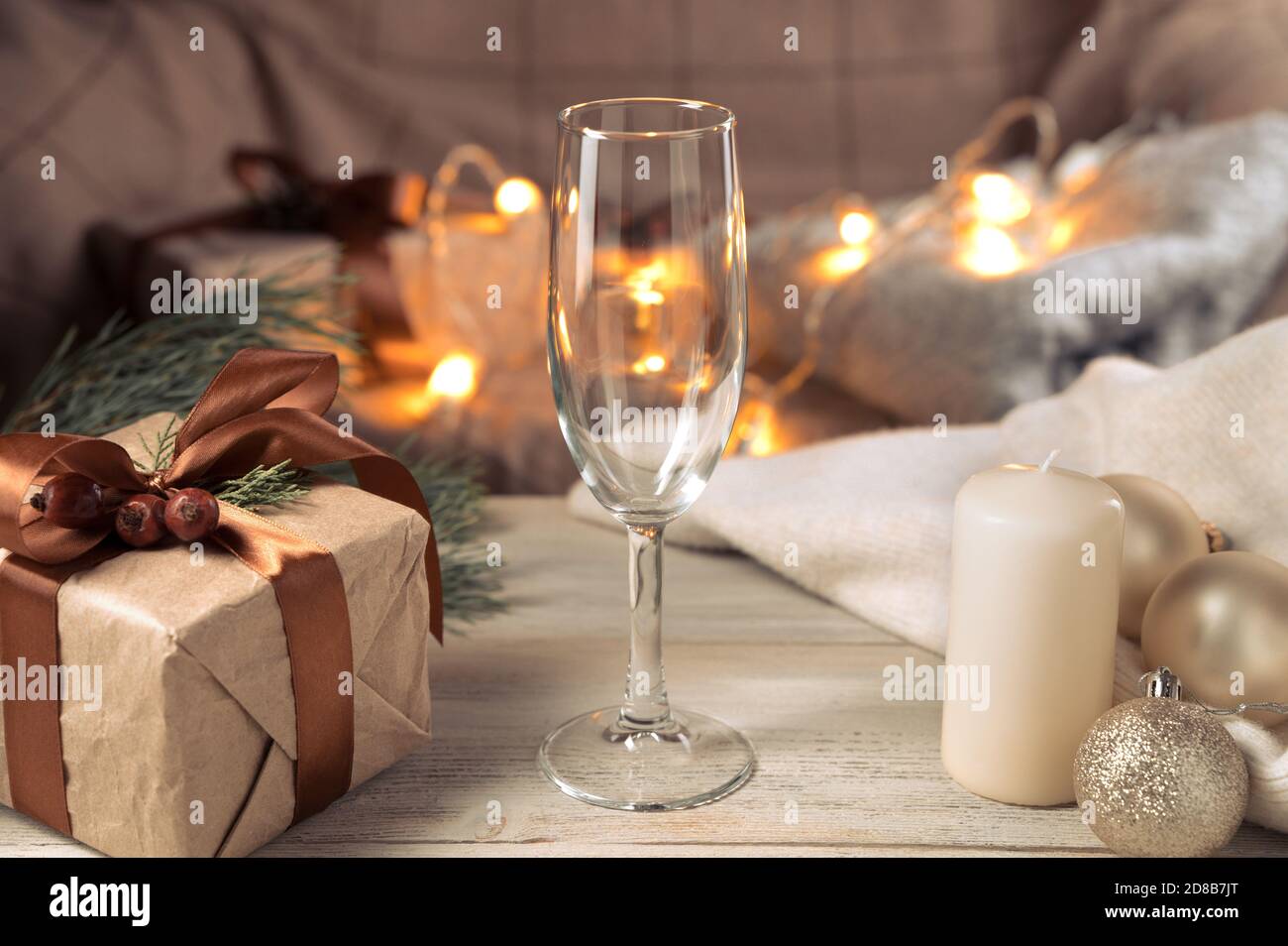 Weihnachtlicher Hintergrund mit einem leeren Sektglas in gemütlicher Atmosphäre. Stockfoto