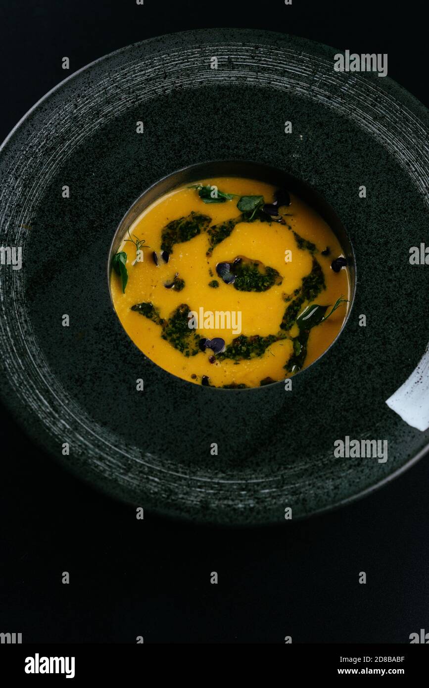 Herbstsuppe mit Kürbiscreme auf schwarzem Hintergrund Stockfoto