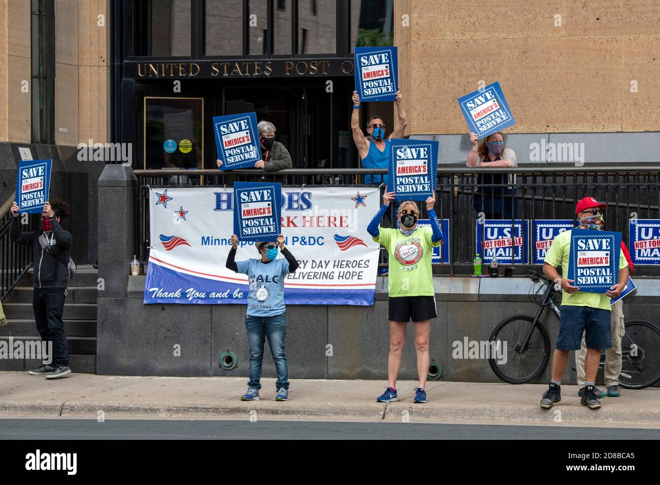 Minneapolis, Minnesota. Postarbeiter sammeln sich, um zu fordern, dass der Kongress handeln, um die Post zu retten. Demonstranten mit Masken, die Schilder halten Stockfoto