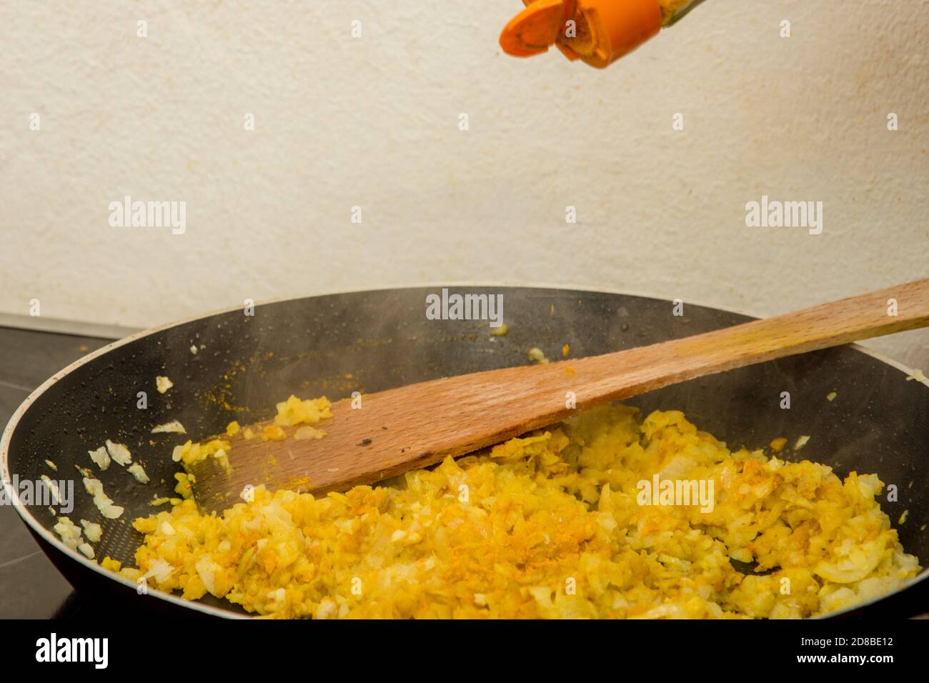 Legen Sie etwas indisches Curry auf die Mischung aus Zwiebel und Andere Gewürze in der heißen Pfanne Stockfoto