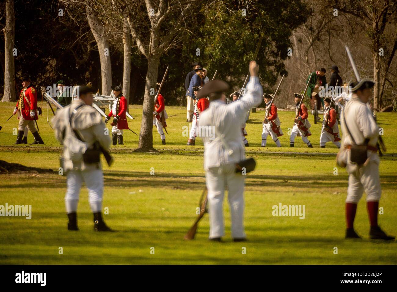 Rebellen laden ihre Musketen, während Redcoats auf das Schlachtfeld bei einer historischen Nachstellung einer Schlacht der amerikanischen Revolution in A Huntington Beach, C marschieren Stockfoto