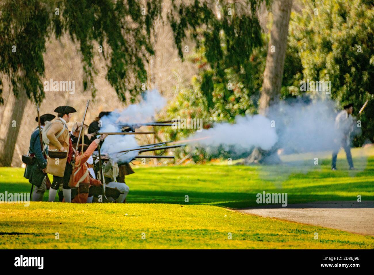 Rebellen-Soldaten geben in einem Park in Huntington Beach, CA, einem historischen Nachstellen einer Schlacht des amerikanischen Revolutionskriegs ein Moschusfeuer zurück. Stockfoto