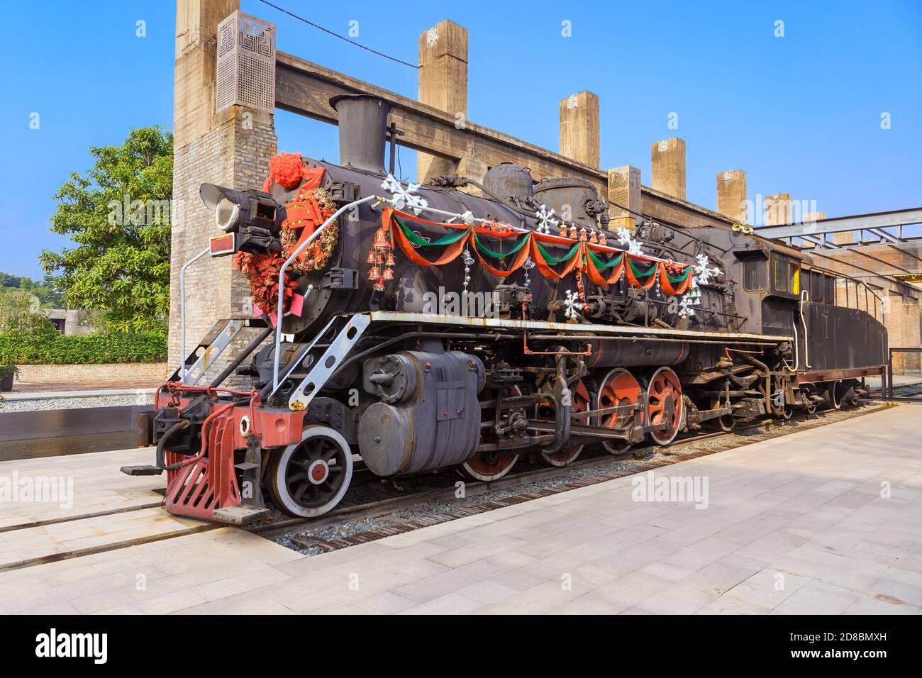 Eine Dampflokomotive mit bunten festlichen Dekorationen auf der Plattform In einem Bahnhof.Festlich oder weihnachten Hintergrund Stockfoto