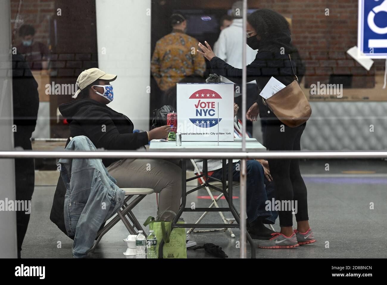 New York City, USA. Oktober 2020. Eine Frau fällt den Stimmzettel in eine Wahlurne eines Wahllokal, das im Brooklyn Museum am 5. Tag der vorzeitigen Abstimmung für die Präsidentschaftswahlen 2020 im Stadtteil Brooklyn von New York City, NY, am 28. Oktober 2020 eingerichtet wurde. Mit weniger als einer Woche vor dem Wahltag wird geschätzt, dass 66 Millionen Menschen bereits ihre Stimmzettel abgeben haben und damit die Rekorde in der Geschichte der US-Wahlen brechen. (Anthony Behar/Sipa USA) Quelle: SIPA USA/Alamy Live News Stockfoto