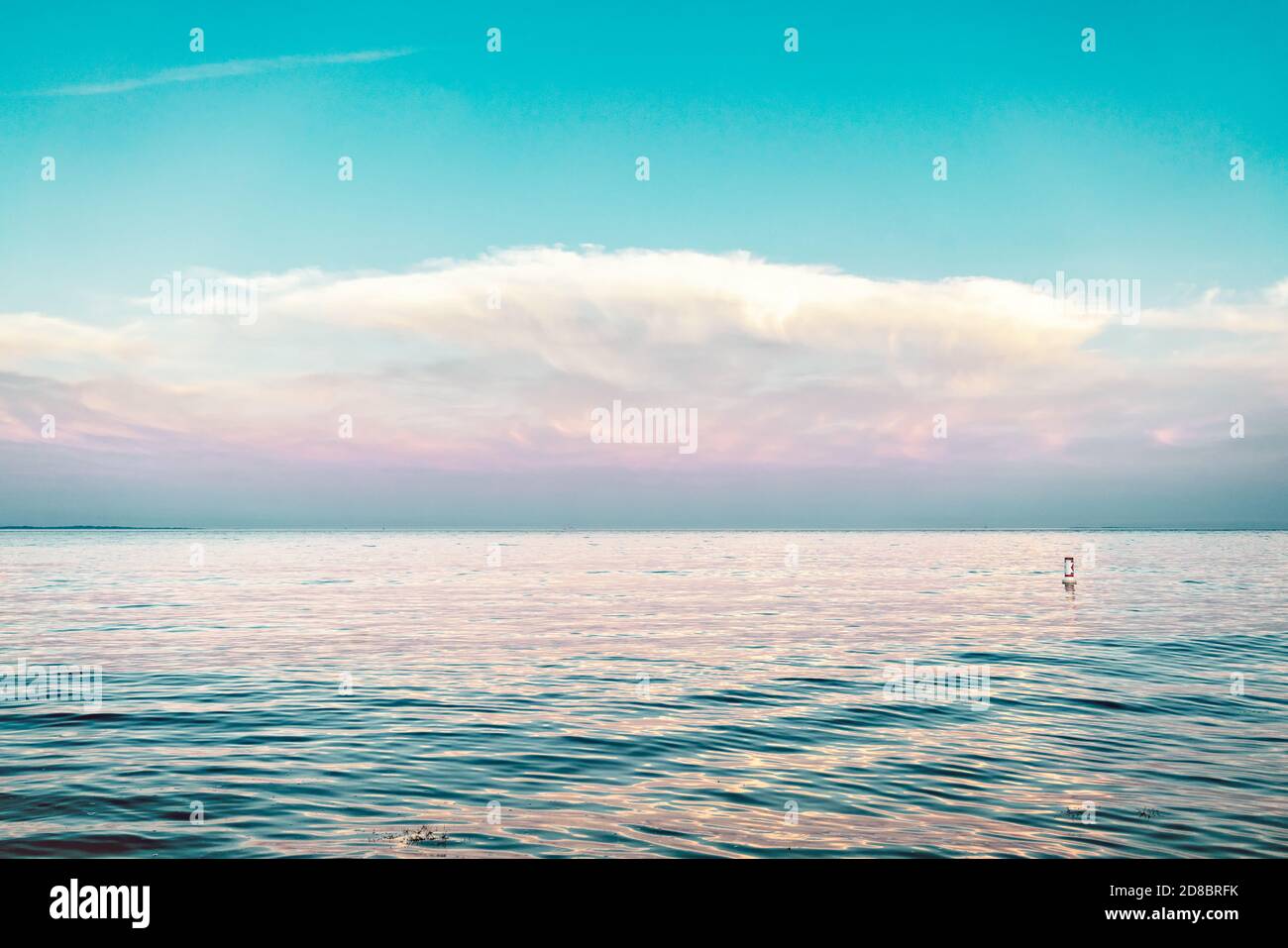 Blaue Stunde mit einem pastellfarbenen Himmel und Wolken Blick über das Wasser mit rosa und lila Reflexen auf einem aqua Meer mit einer Boje. Black Point Beach, Niantic, Stockfoto