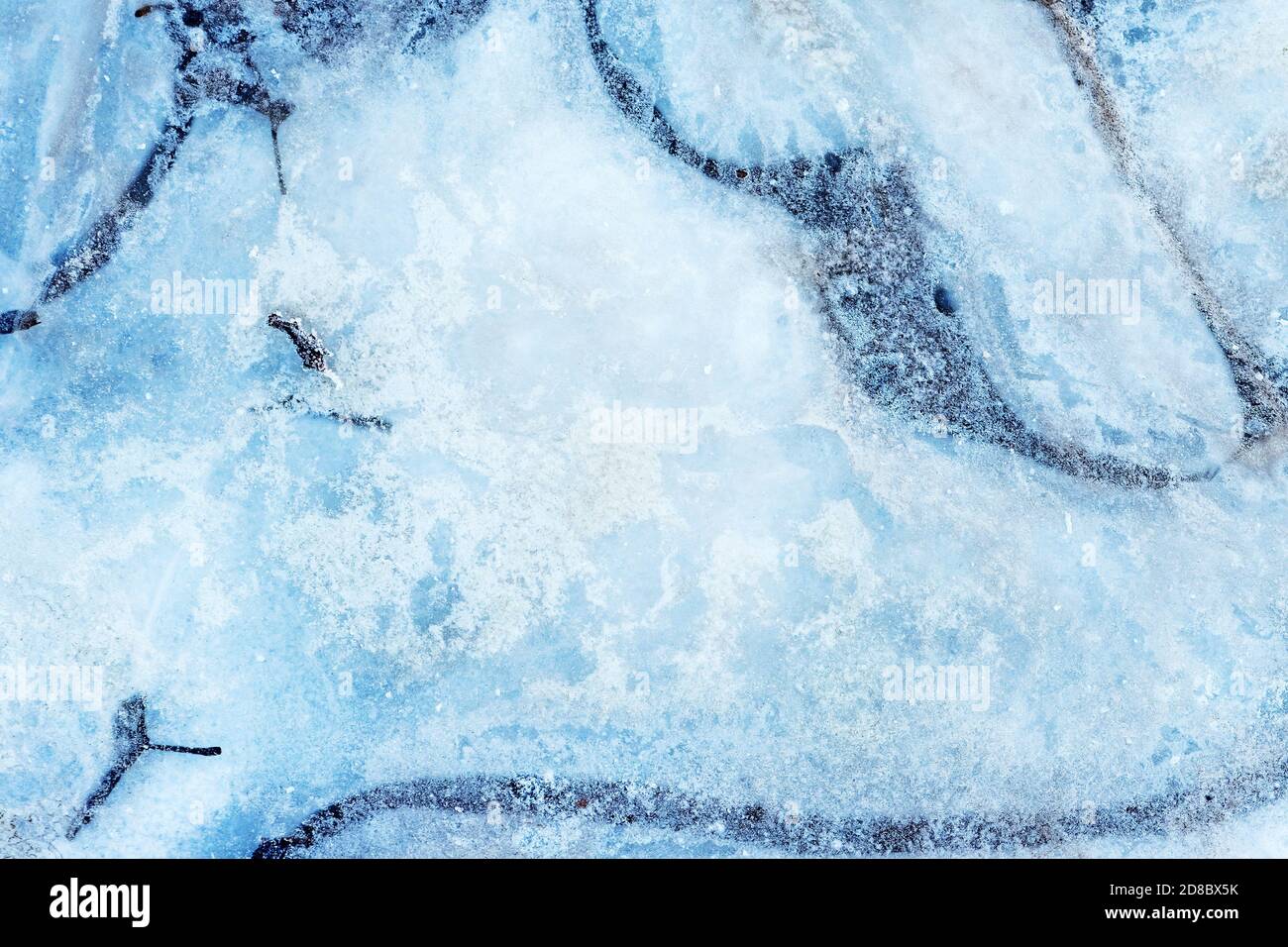 Oberfläche des natürlichen Eises, der im Winter auf dem Wasser bedeckt ist. Eisstruktur mit Zwischenfällen von Frost, Kristallen von gefrorenem Wasser. Stockfoto