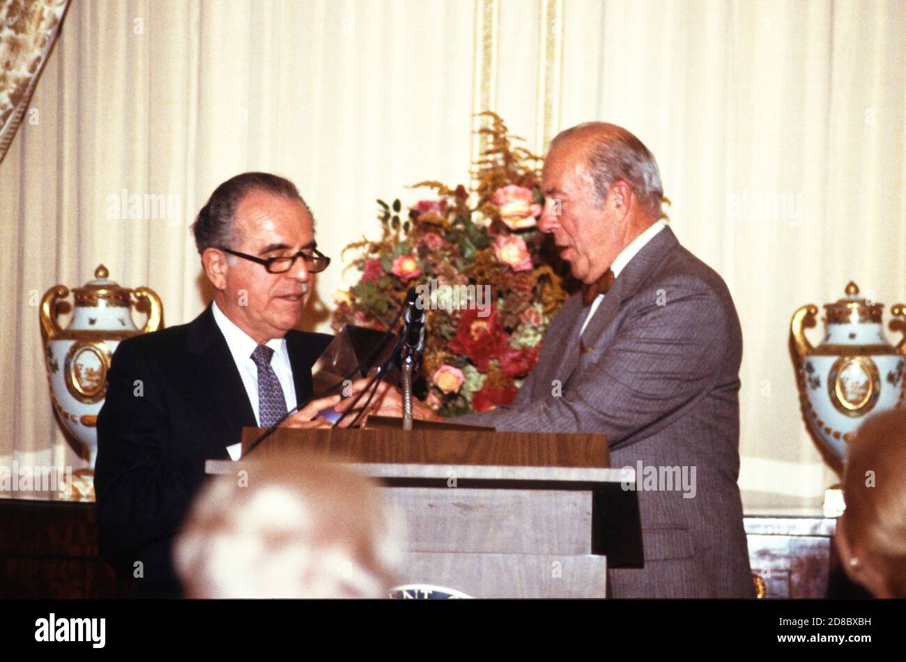 US-Außenminister George P. Shultz, rechts, nimmt am 2. Dezember 1987 im US-Außenministerium in Washington, DC, einen Preis der US-Informationsagentur vom Direktor der USIA, Charles z. Wick, links, entgegen.Quelle: Arnie Sachs / CNP / MediaPunch Stockfoto