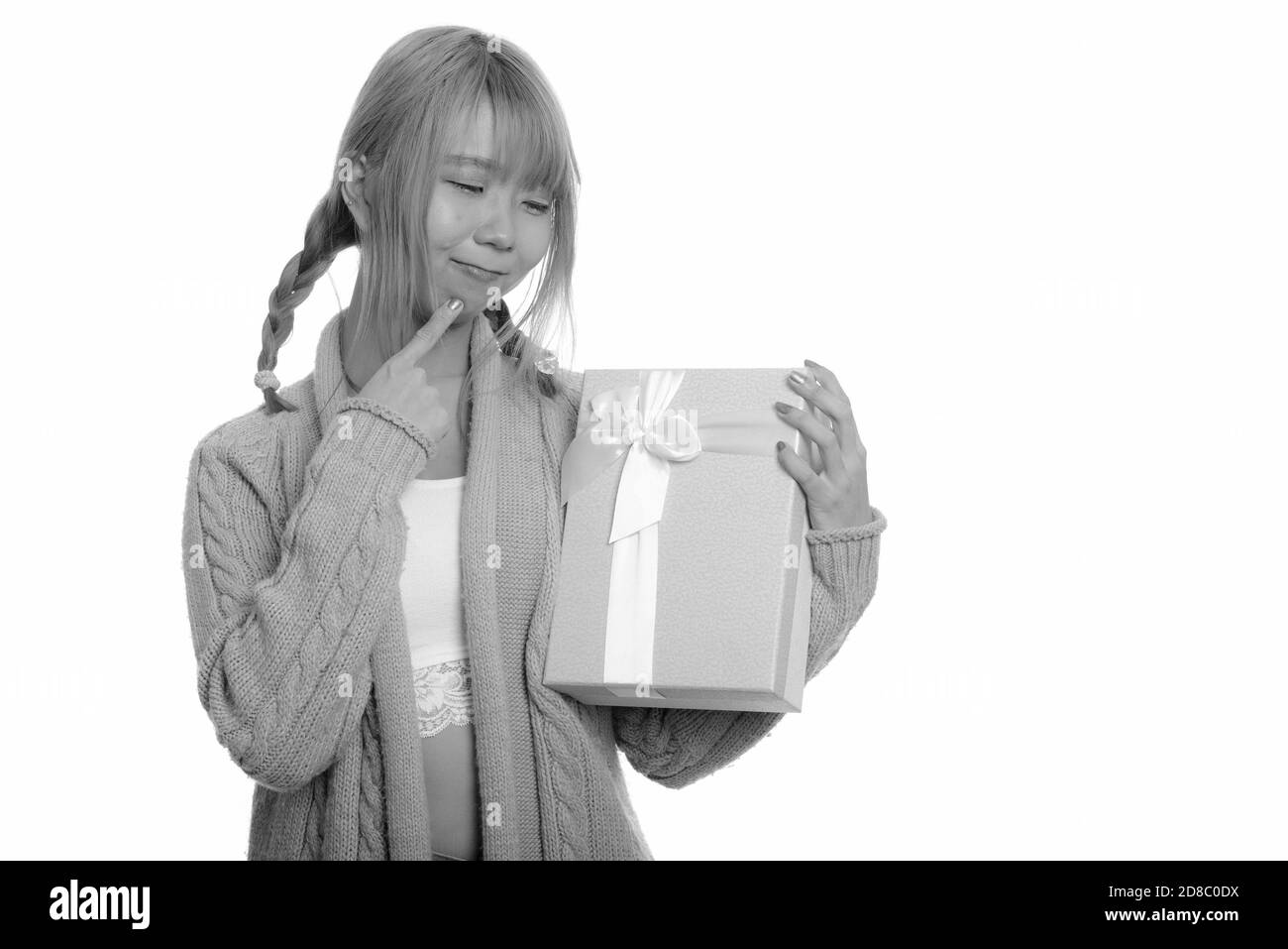 Junge süße asiatische Frau mit Geschenk Box beim Denken Stockfoto