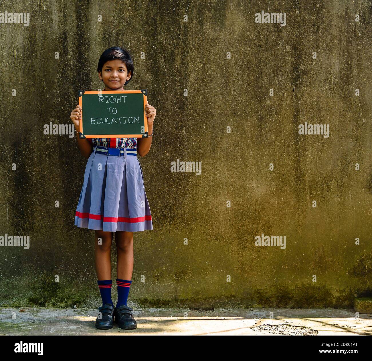 Durgapur, Indien - Oktober 15,2020. Ein kleines indisches ländliches Mädchen mit einem grünen Brett geschrieben ' Recht auf Bildung ', EIN Konzept Bild. Stockfoto