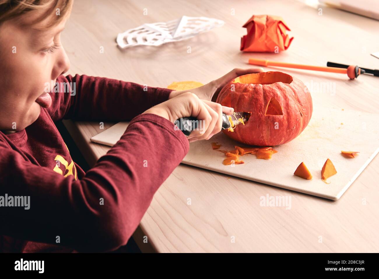 Halloween, Dekoration und Urlaub Ideen- Nahaufnahme des Kindes mit Messer Schnitzerei Kürbis oder Jack-o-Laterne. 6 Jahre junge hat Heimfamilie Spaß Aktivität. Mama Stockfoto