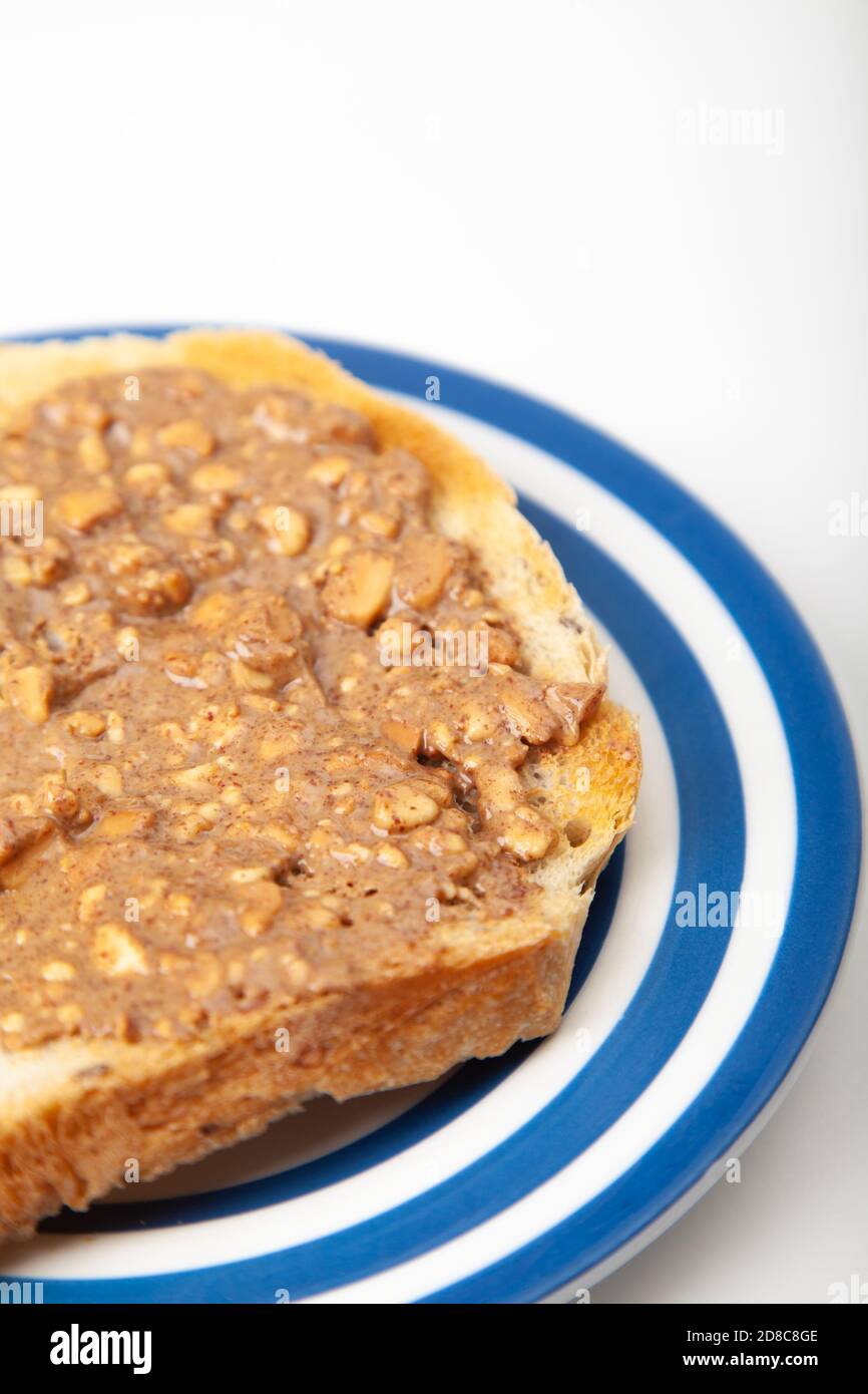 Eine Scheibe Toast mit knackiger Erdnussbutter darüber verteilt. Stockfoto