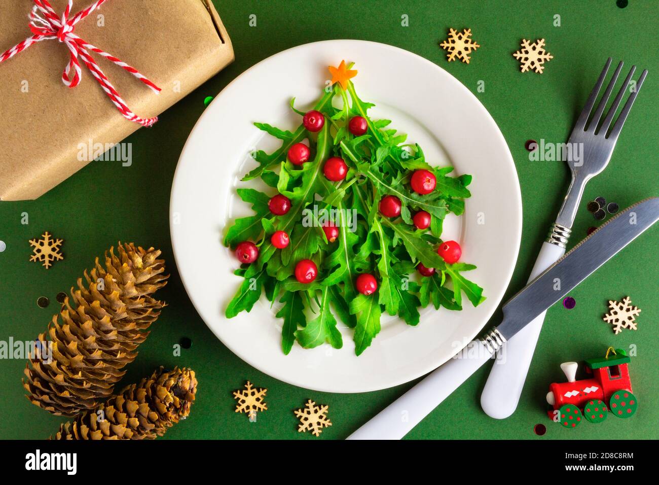 Der Weihnachtsbaumsalat auf weißem Teller auf dem Tisch. Flach liegend Stockfoto