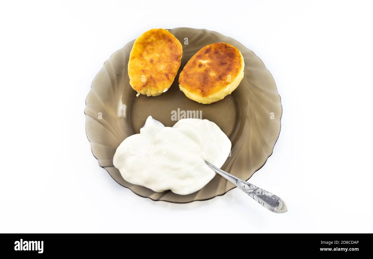 Russischer Käsekuchen auf einem Teller mit saurer Sahne auf einem ...