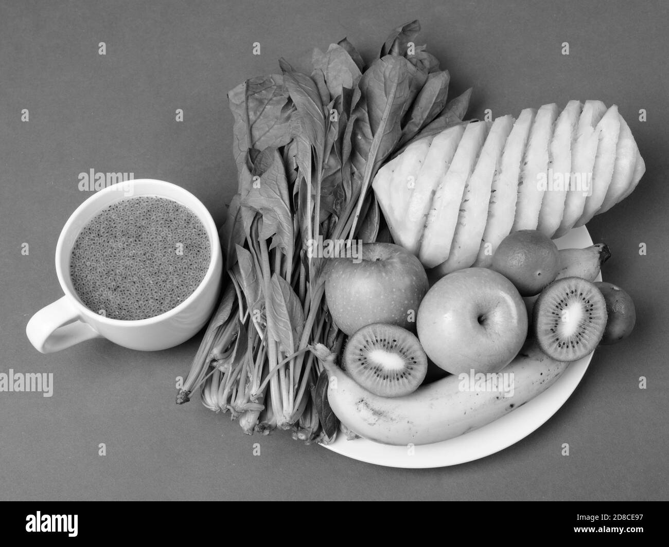 Frisches Obst und Gemüse auf dem Teller mit Chia Samen auf Becher Stockfoto
