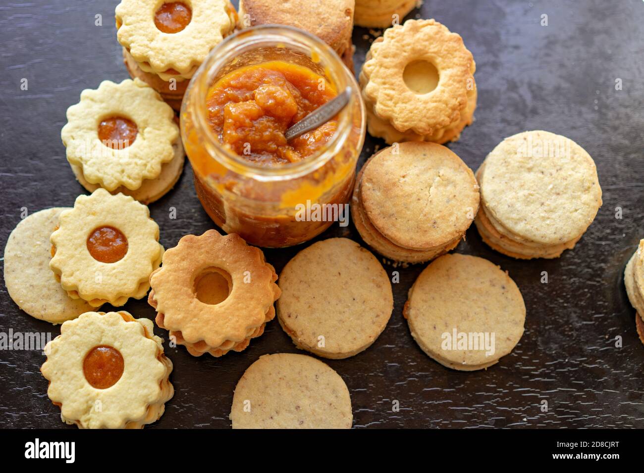 Herstellung von traditionellen rustikalen linzer Keks Cookies vintage Backen mit einem Einmachglas mit Marmelade Stockfoto