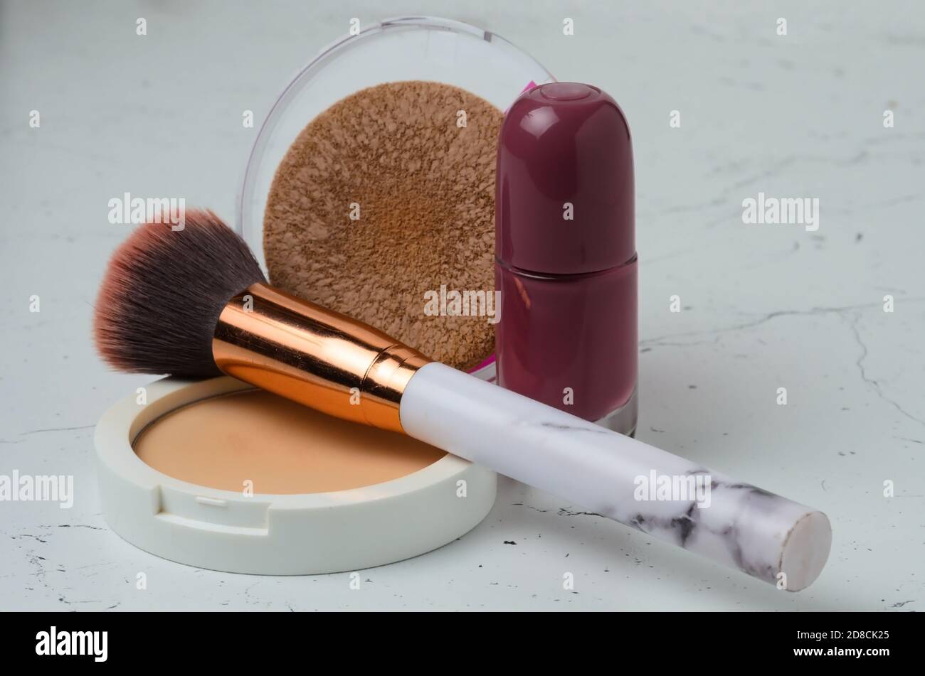 Ein alter Schminkpinsel mit Puder und Nagellack auf einer texturierten Tischoberfläche. Selektiver Fokus. Stockfoto