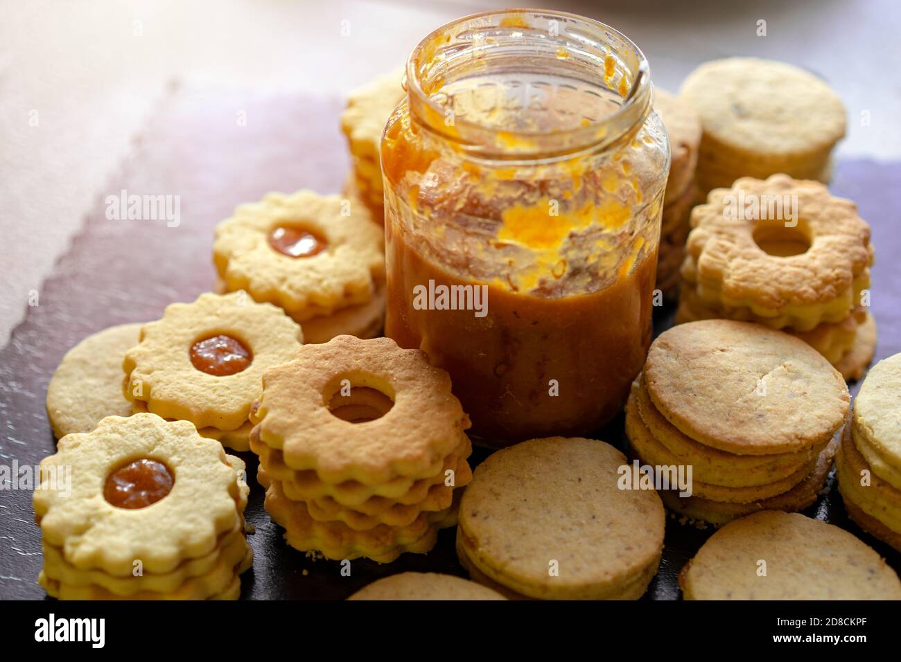 Herstellung von traditionellen rustikalen linzer Keks Cookies vintage Backen mit einem Glas Marmelade . Stockfoto