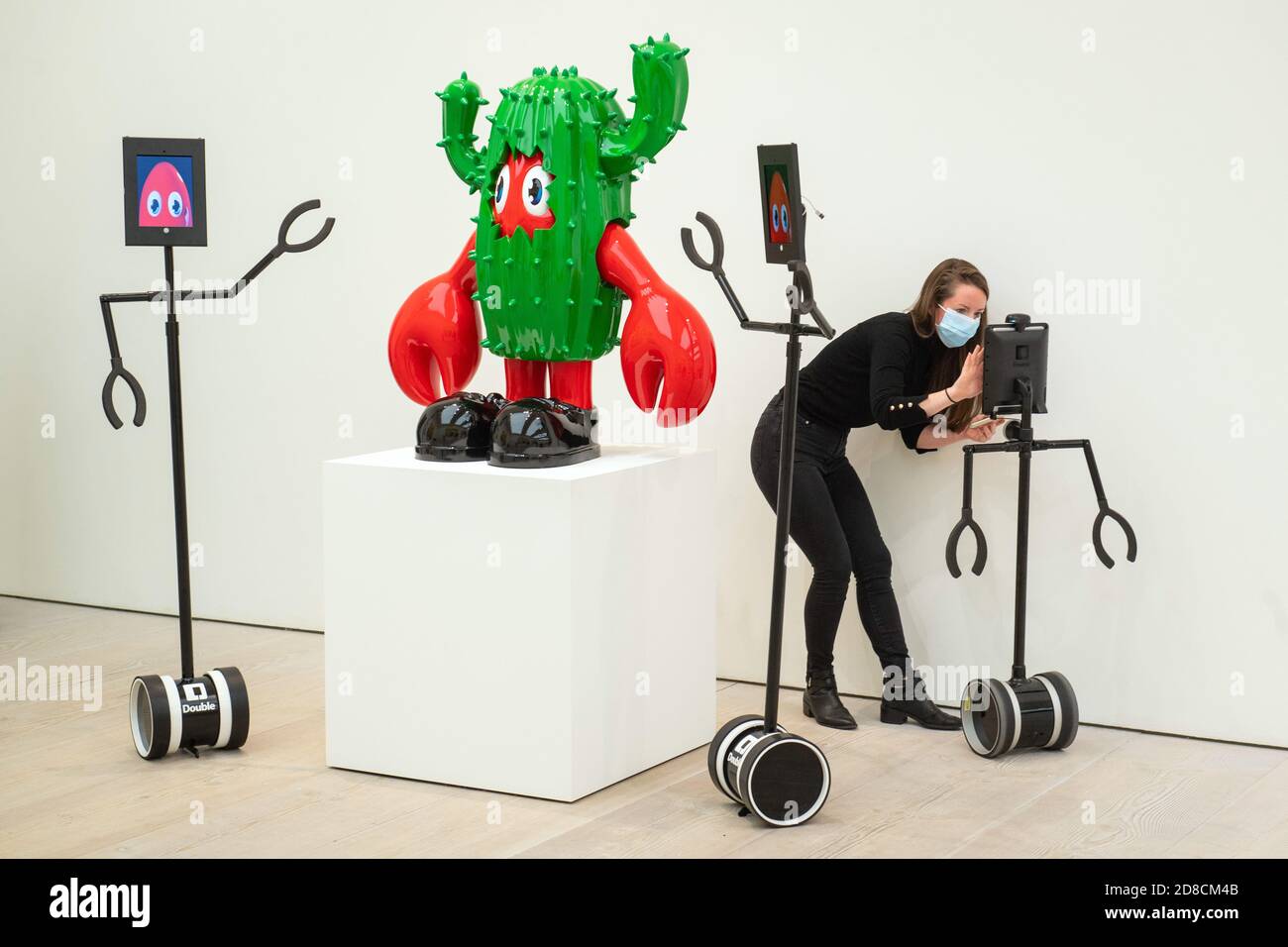 Die Mitarbeiter der Galerie haben ferngesteuerte Roboter eingerichtet, mit denen Kunstwerke in einer Vorschau der Ausstellung "Philip Colbert: Lobsteropolis" in der Saatchi Gallery in London aus der Ferne betrachtet werden können, die dem Publikum die Möglichkeit bietet, Kunstwerke vor Ort oder über Roboter bequem von zu Hause aus zu betrachten. Stockfoto