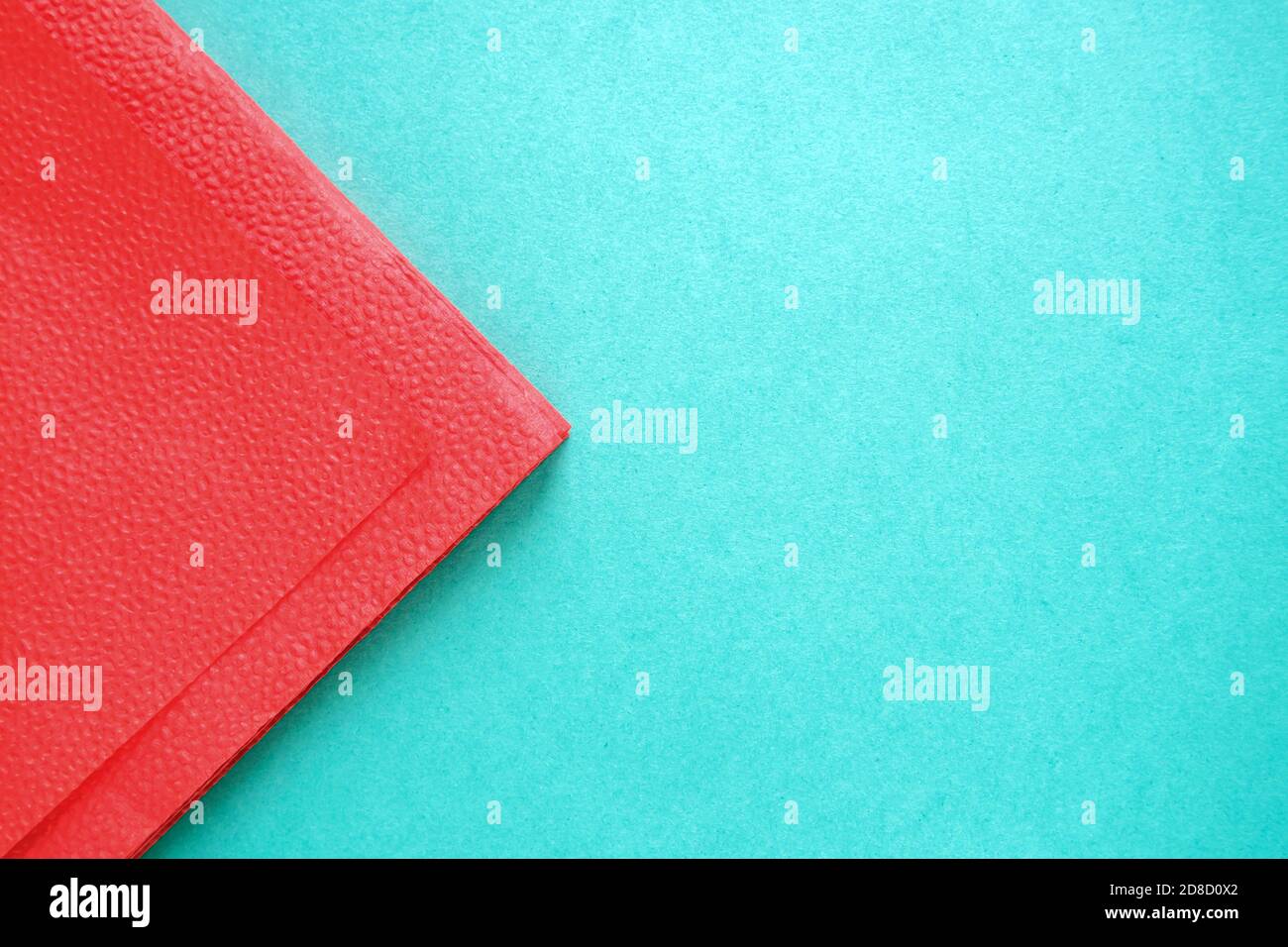 Teil aus roter Papierserviette auf blauem Hintergrund aus Karton, Kopierraum Stockfoto