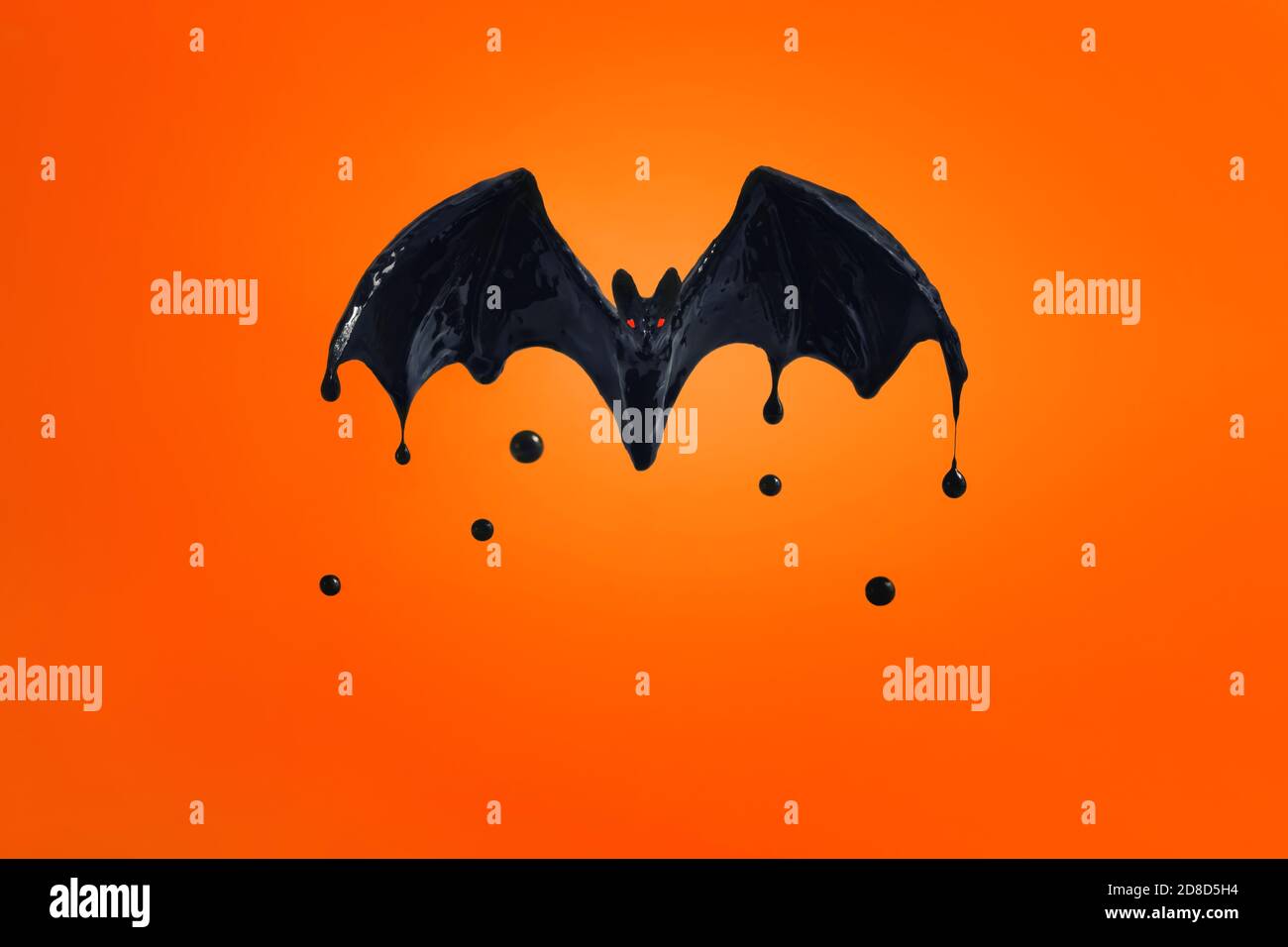 Schwarze Fledermaus mit roten Augen auf orangefarbenem Hintergrund. Stockfoto